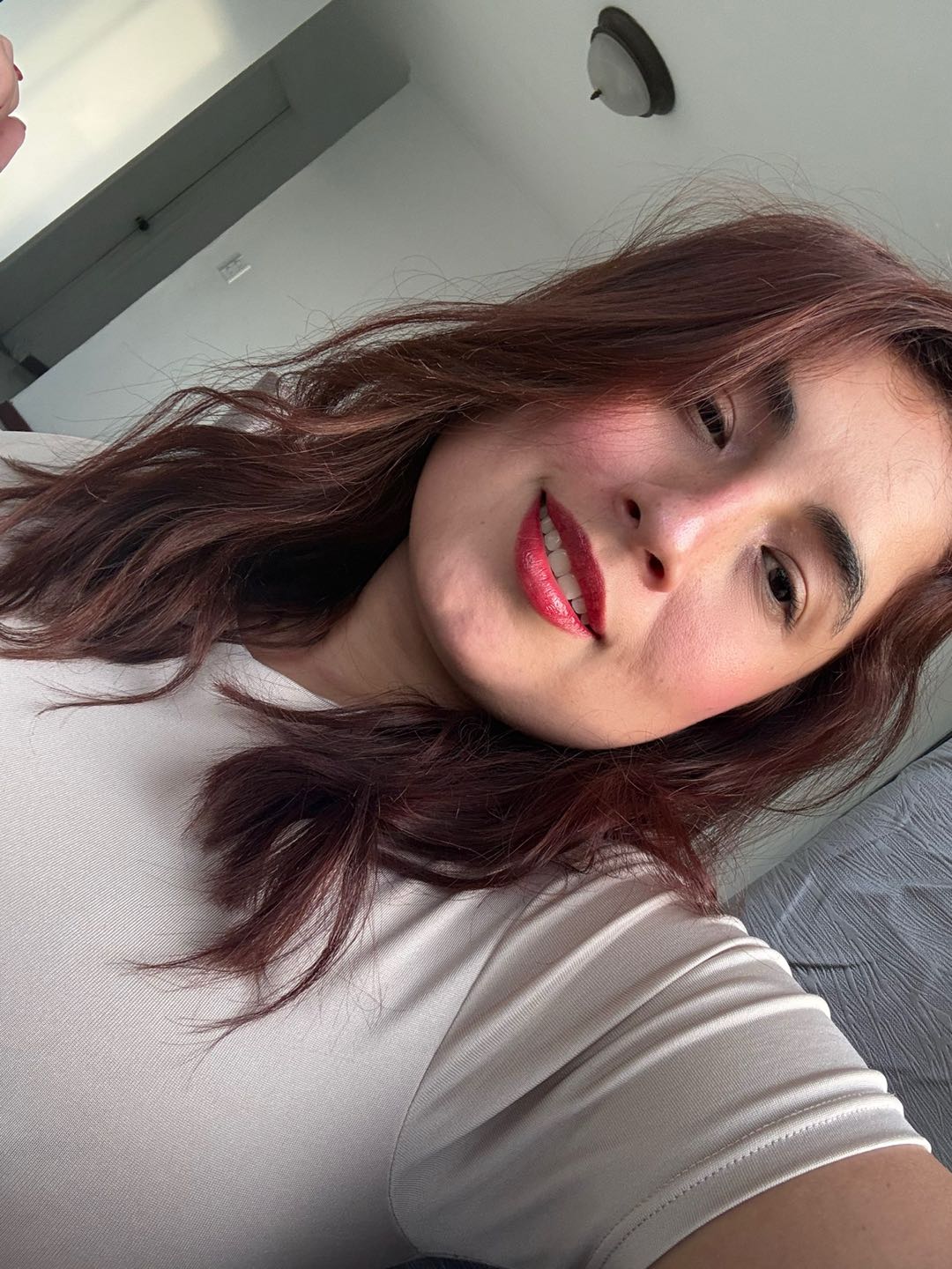 Girl from Colombia smiling into a phone camera at home