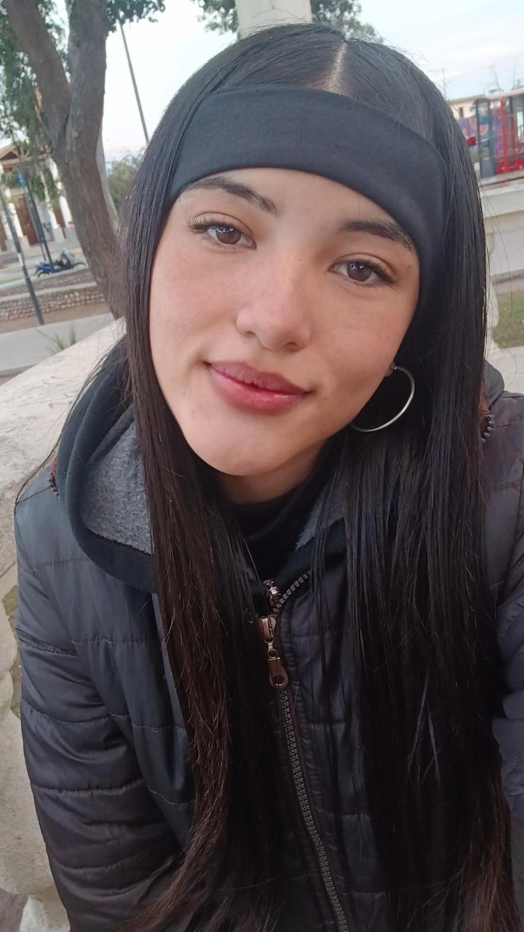 Girl from Argentina in a beanie smiling at her phone camera before a match